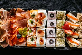 A platter of assorted appetizers including meats cheeses and garnished small bites