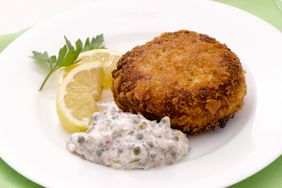 tartar sauce on plate with fish cake and lemon slices
