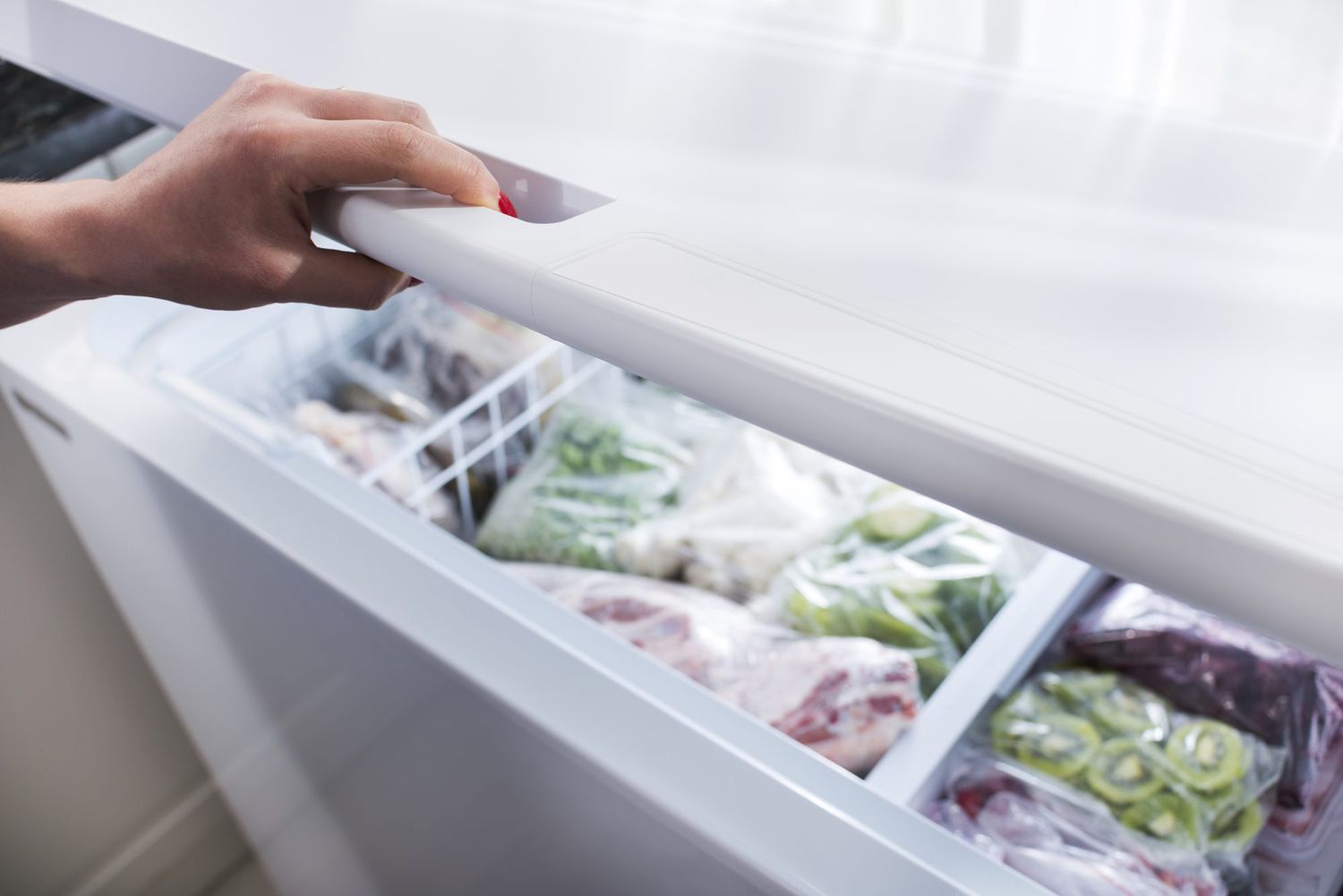 Woman hand opening freezer door