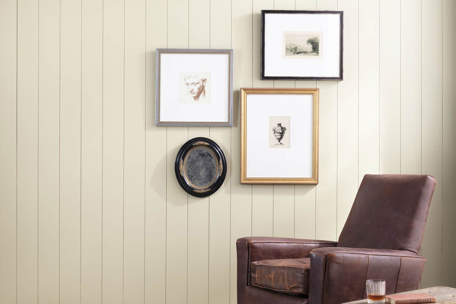 paneled white walls with artwork and a recliner chair