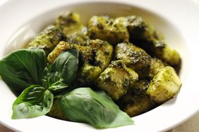 potato gnocchi with basil pesto in white bowl