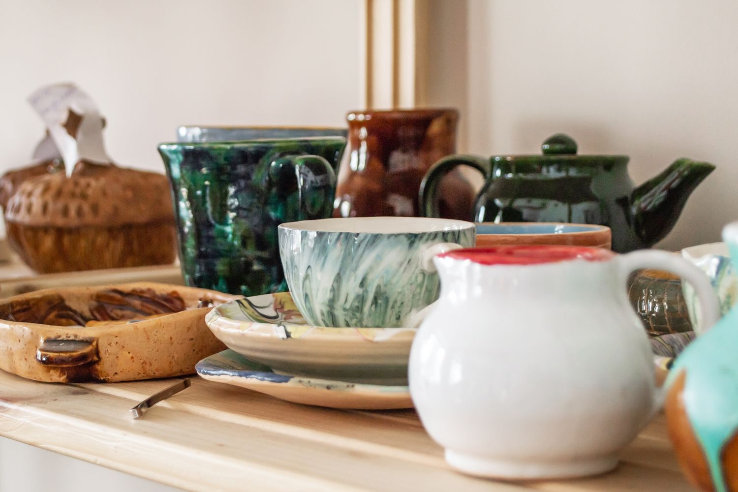 Ceramic cups teapots and dishes arranged on a shelf