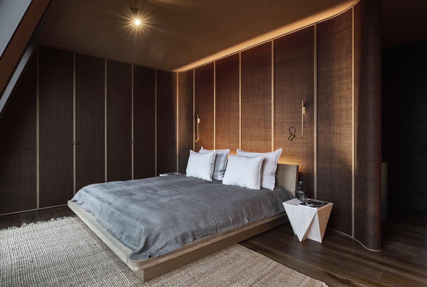a bedroom with natural walls and subtle lighting