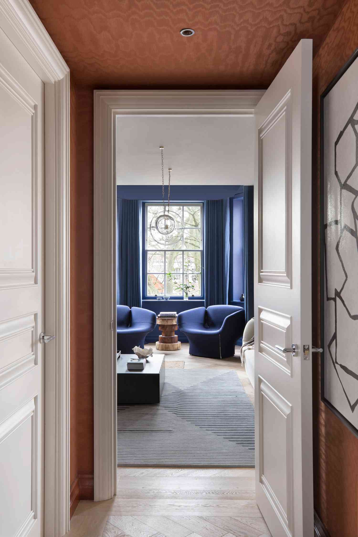 terracotta wallpaper in hallway ending with blue walls