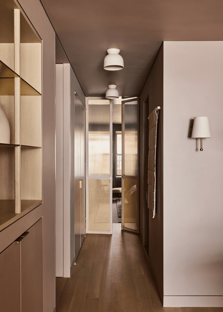 blush pink hallway with shelves and white lamps