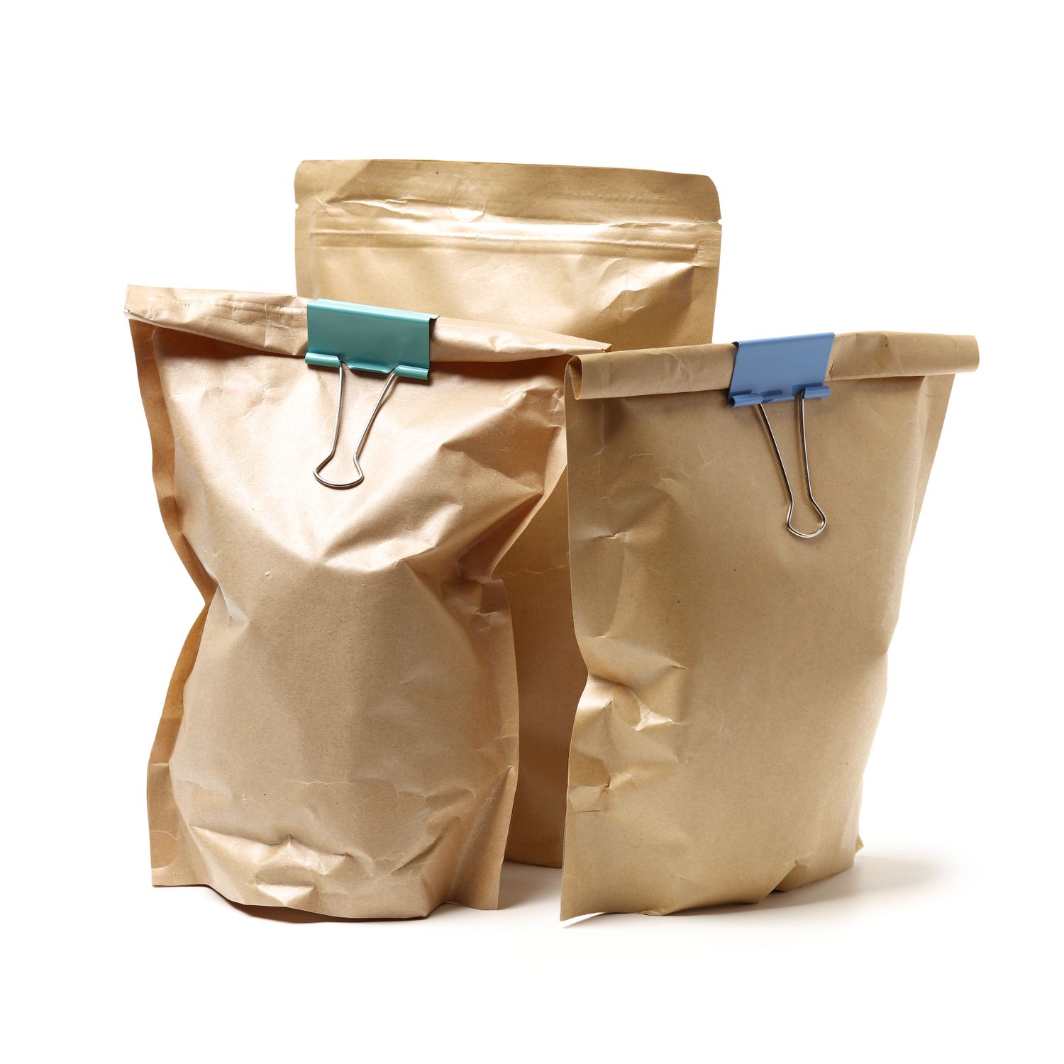 Three brown paper bags secured with binder clips standing upright