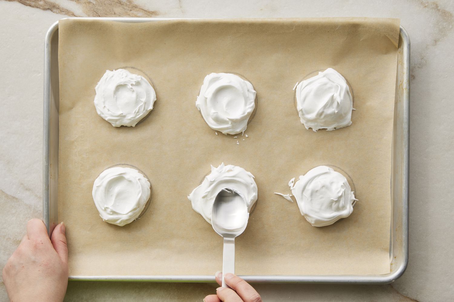Mini Pavlovas meringue in circles on baking sheet with indentations