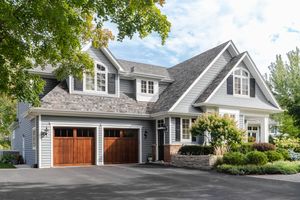 A suburban house with a garage and landscaping driveway in front