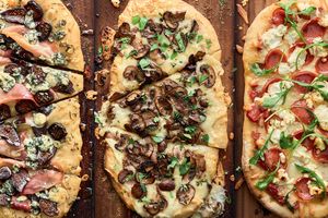 3 different pizzas on grilling planks