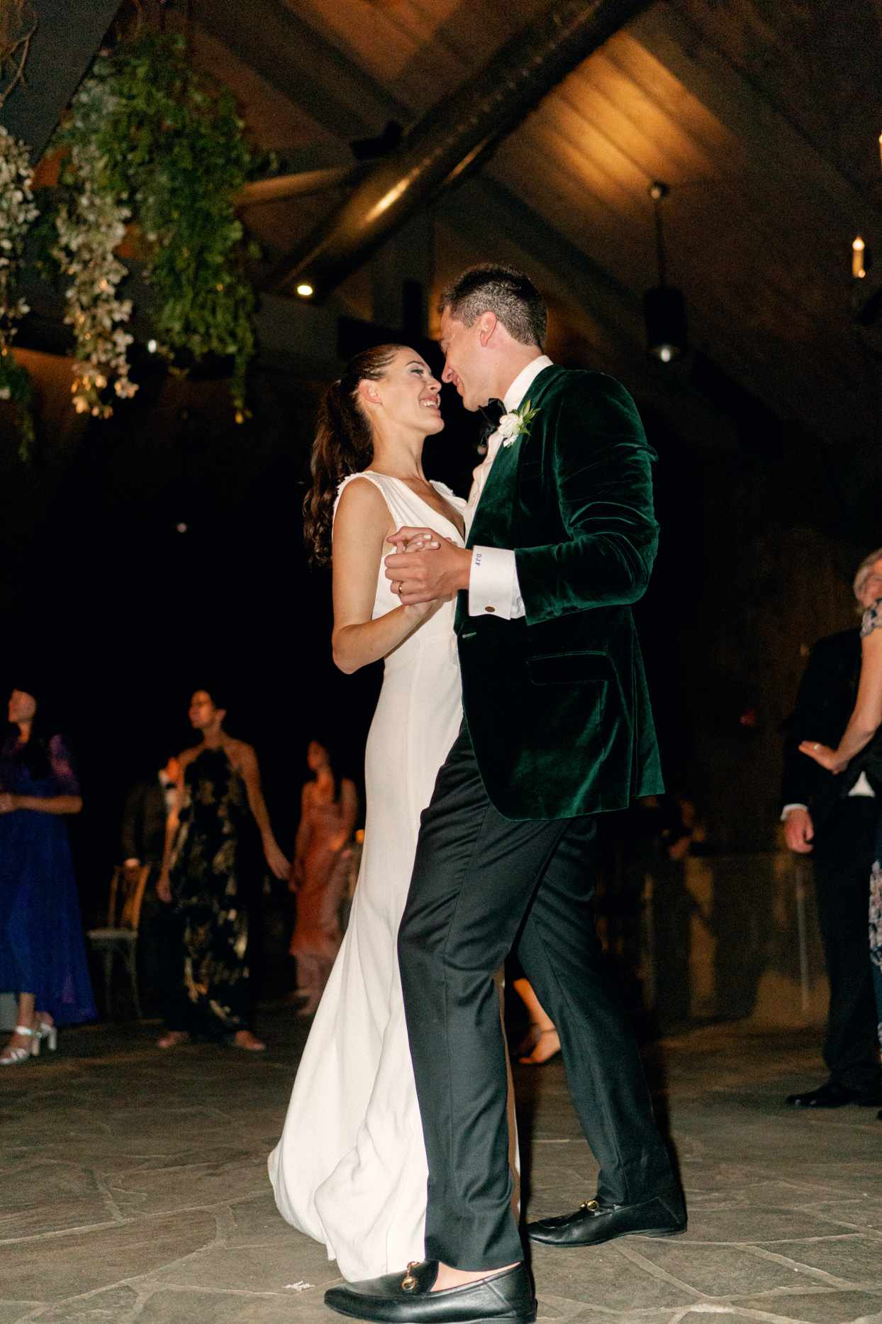 bride and groom share first dance smiling on stone floor