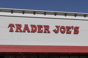 The exterior of a Trader Joes store displaying its logo on the building