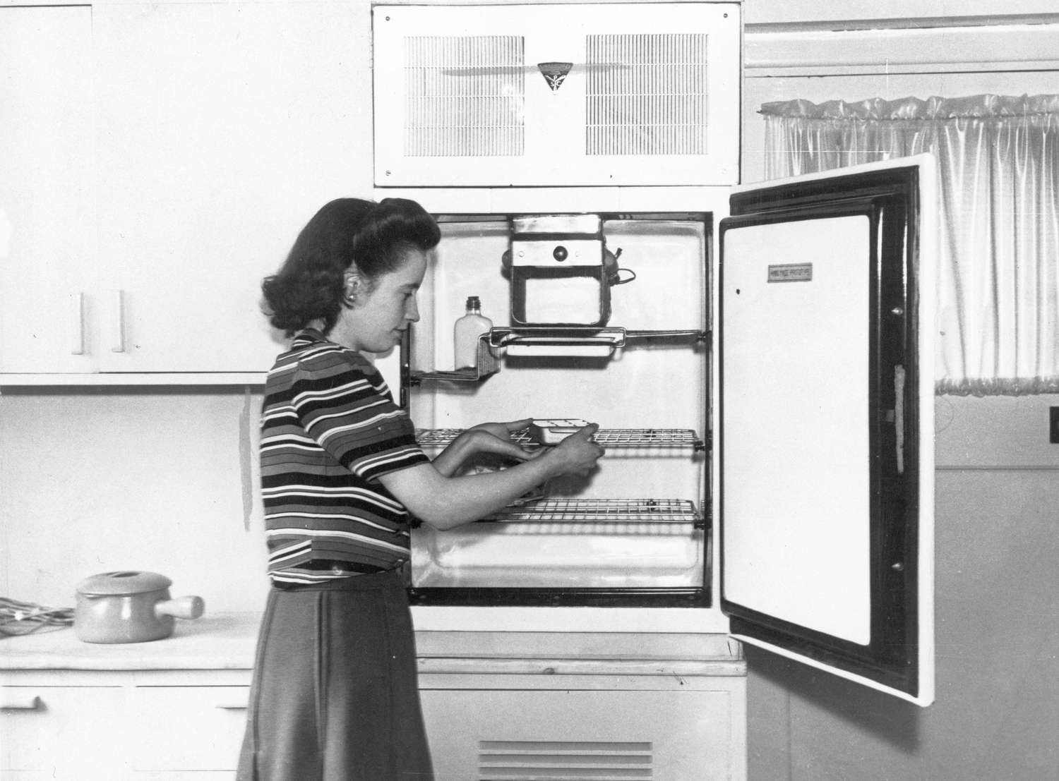 Woman using an old refrigerator