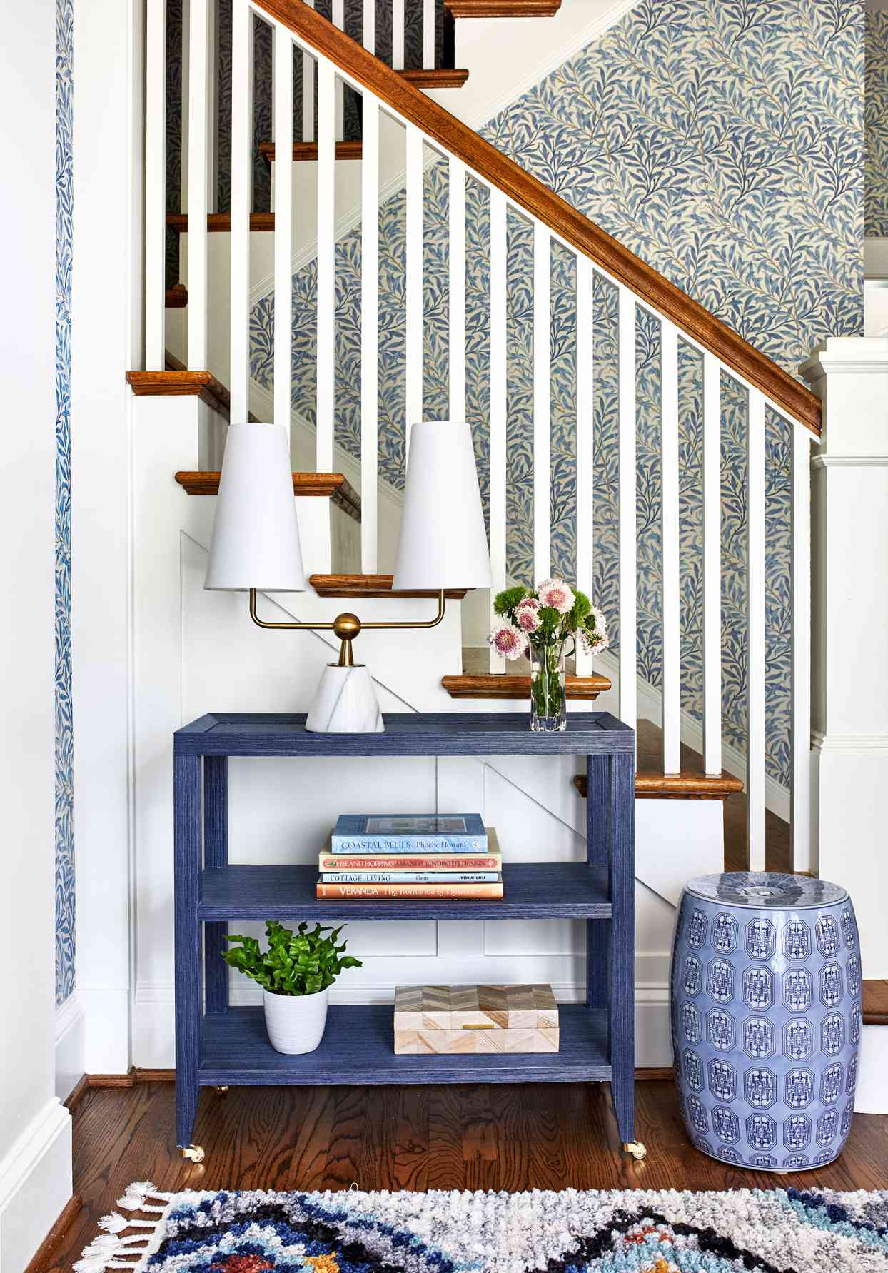 entryway staircase with blue botanical wallpaper
