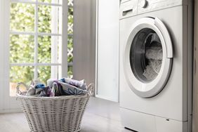 View of laundry room with washing machine and laundry basket