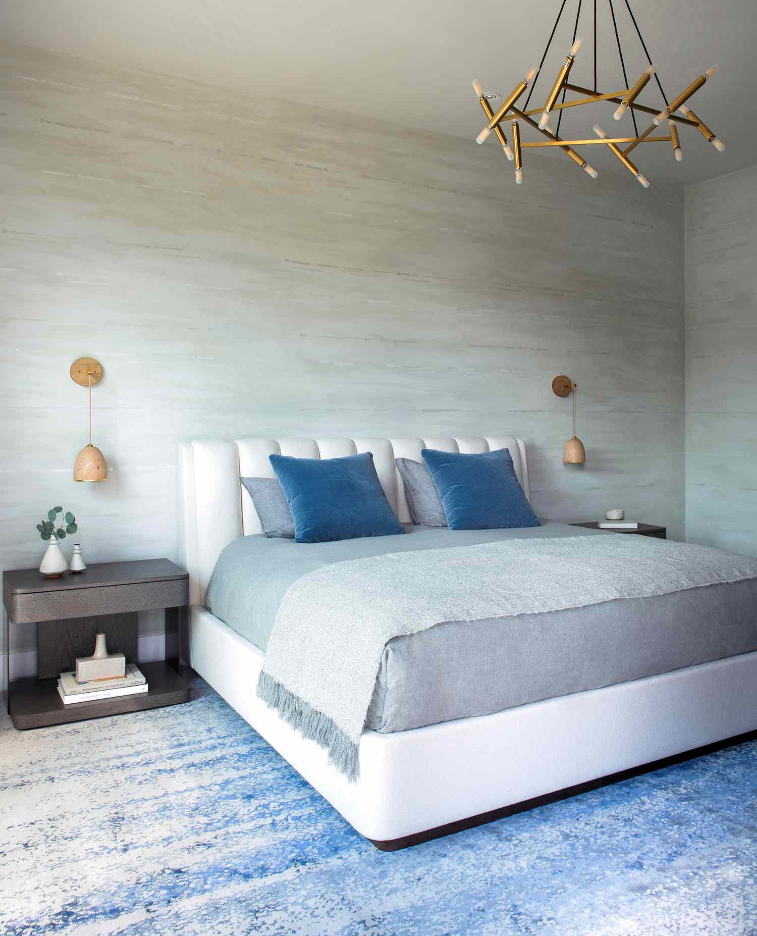 a gray primary bedroom with a blue ombre rug underfoot