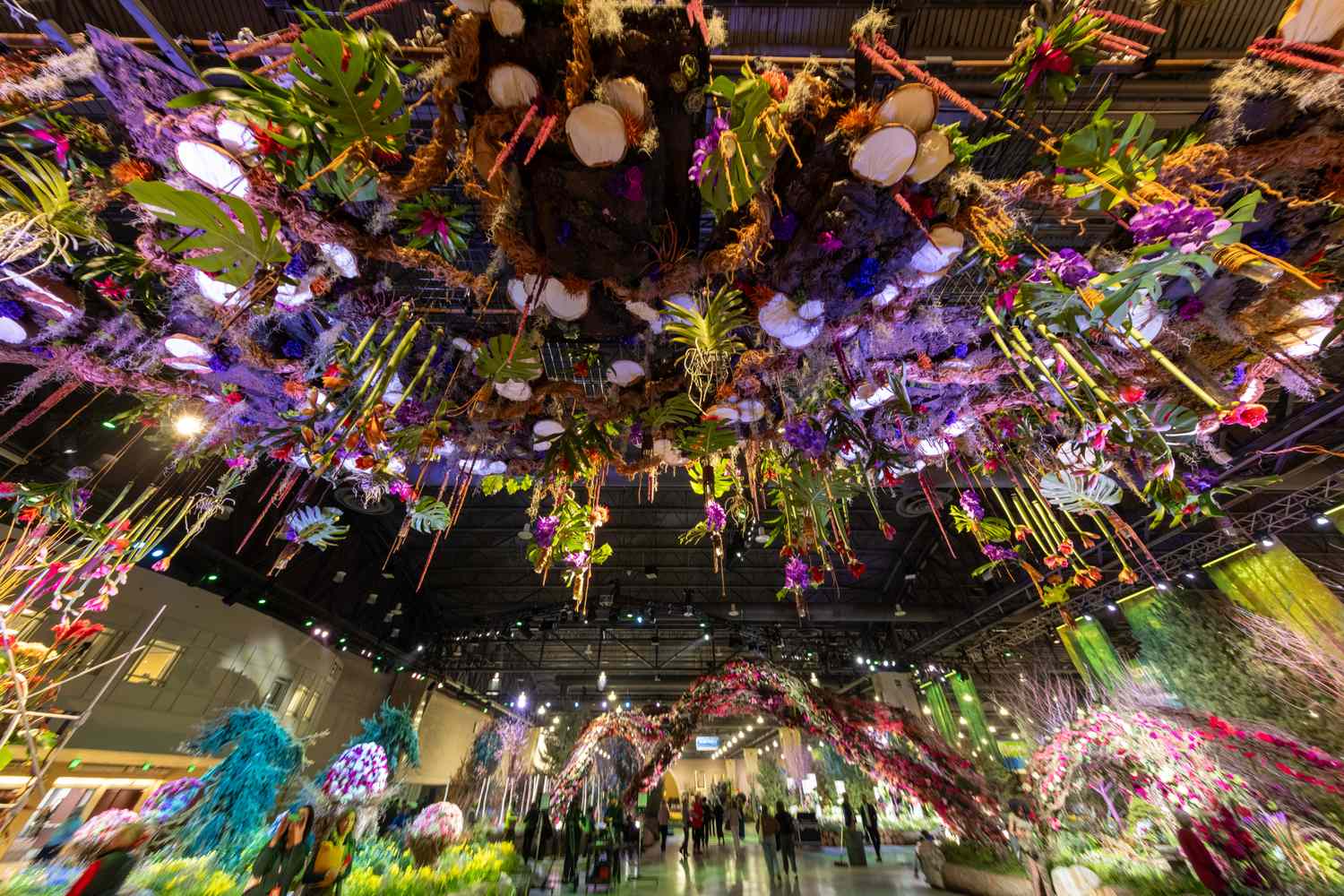 Floral indoor exhibition with suspended decorations and lit displays