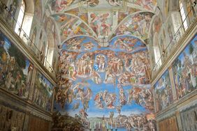 Interior view of the Sistine Chapel showing elaborate frescoes on the walls and ceiling