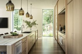 Modern kitchen interior with island pendant lights and large window with view