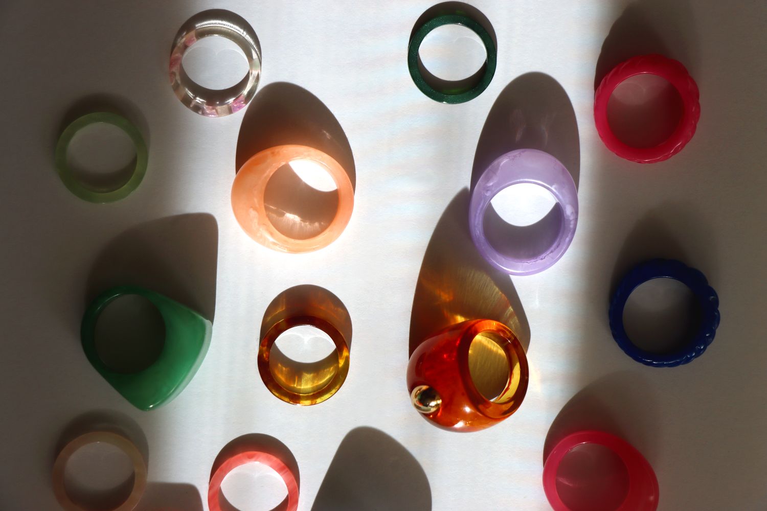 Various translucent and colorful rings arranged on a flat surface casting shadows No identifiable people in the image