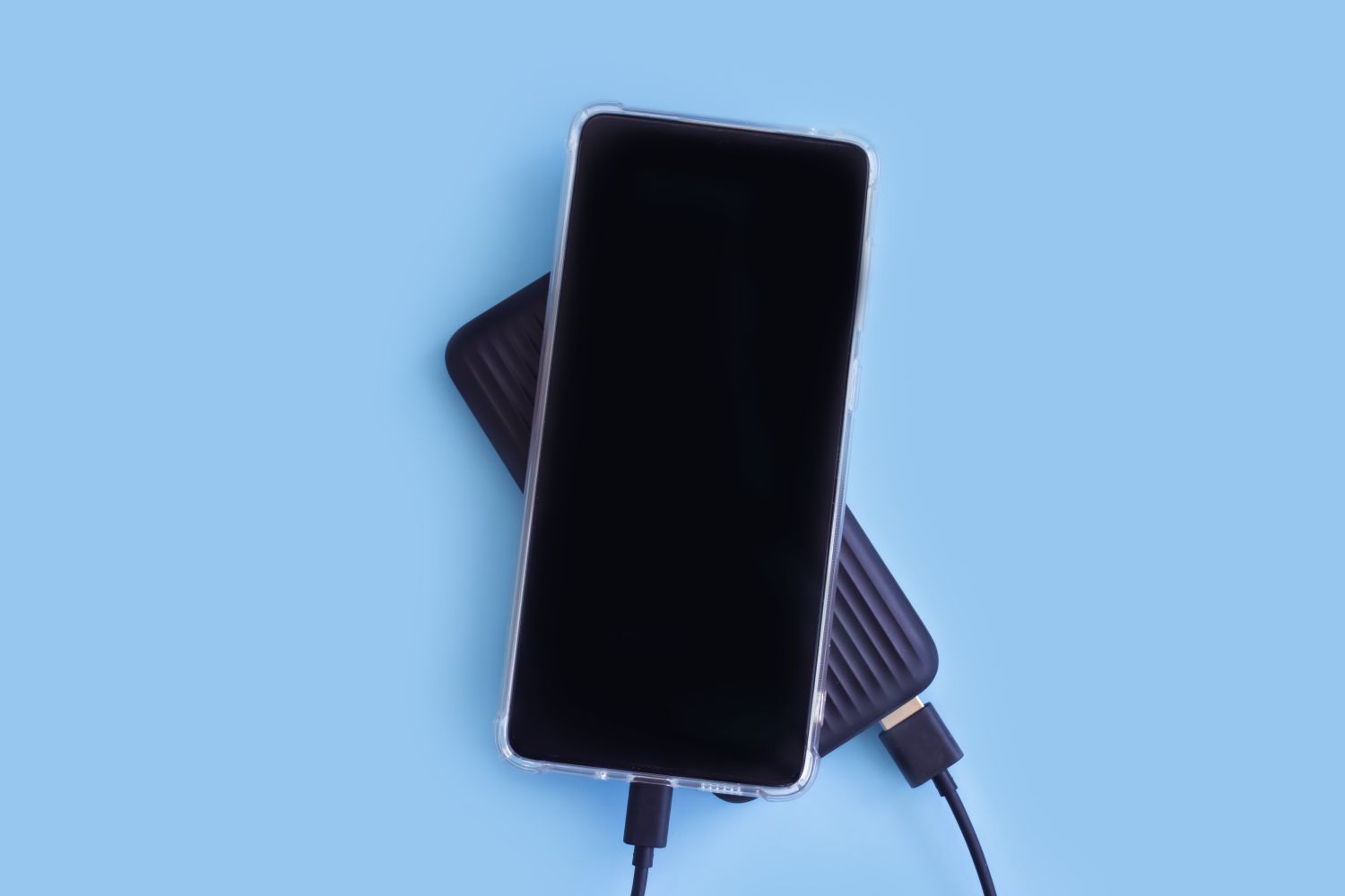 Smartphone and power bank on color background