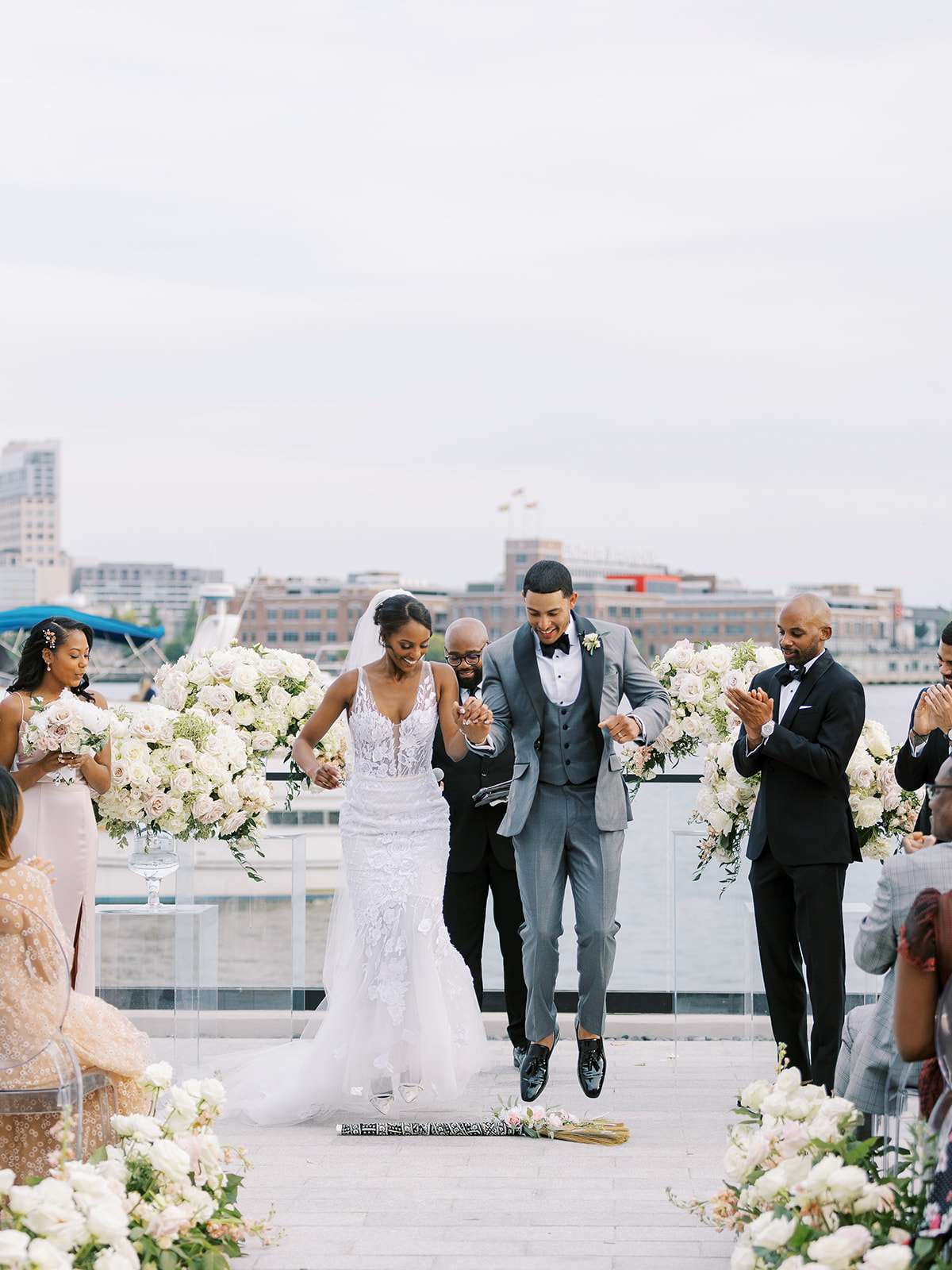 bride and groom jumping over broom