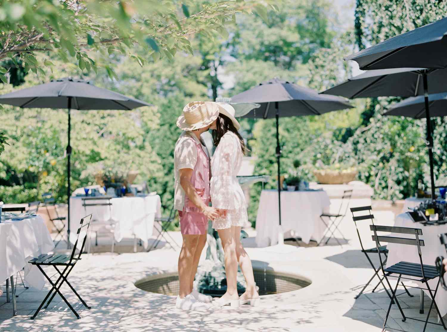 bride and groom kissing by fountain
