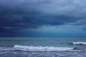 Waves on a beach under cloudy skies
