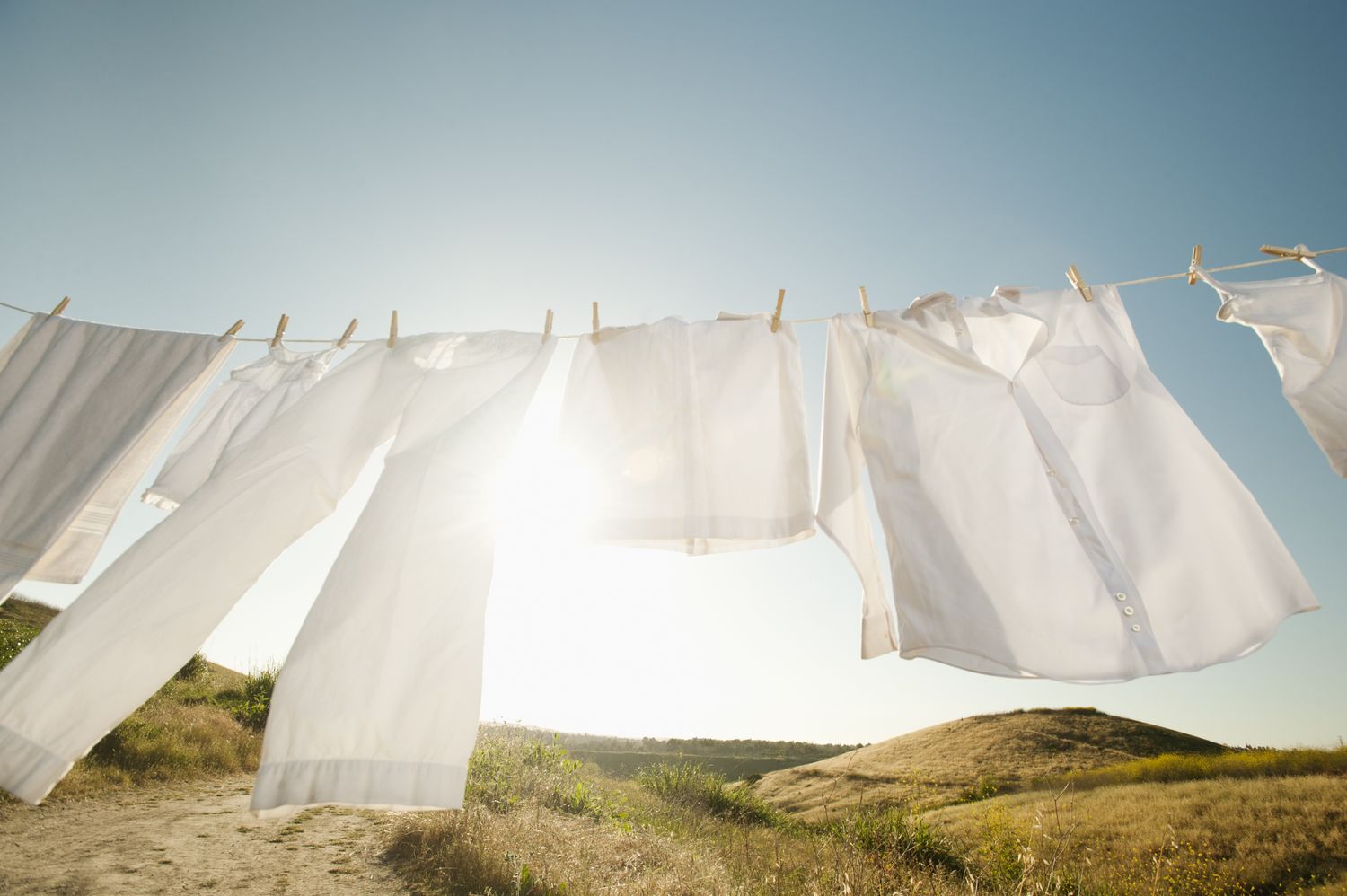 Clothes hanging on a line outdoors in a sunny rural landscape