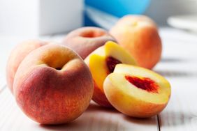 whole peaches on wood table