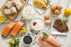 Assorted highprotein foods including fish chicken steak eggs yogurt cottage cheese and beans