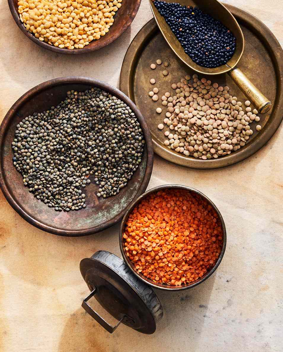 assortment of colorful lentils on slate surface