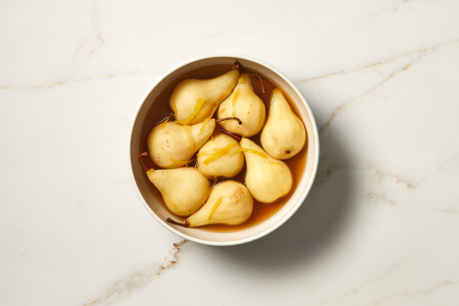 bowl with pears in poaching liquid