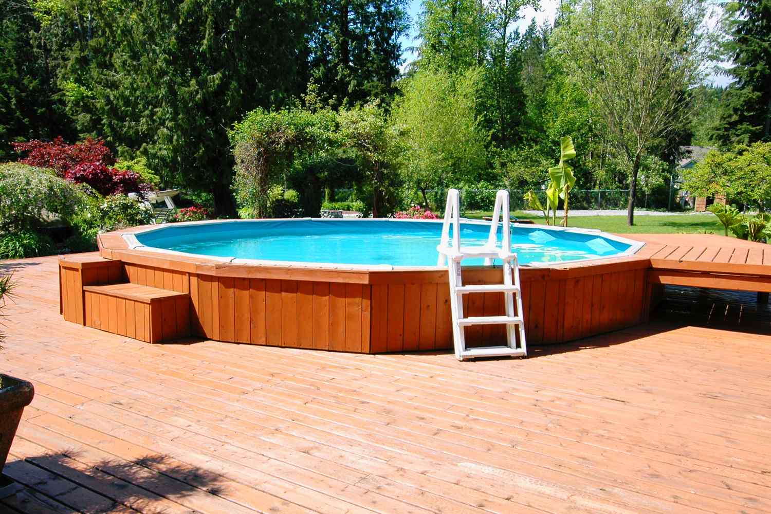 Aboveground swimming pool with wooden decking and attached ladder