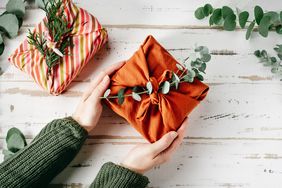 Wrapping a gift in eco friendly reusable fabric package furoshiki