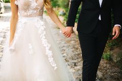 Couple holding hands dressed in formal wedding attire