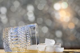 An overturned glass and ice cubes on a surface