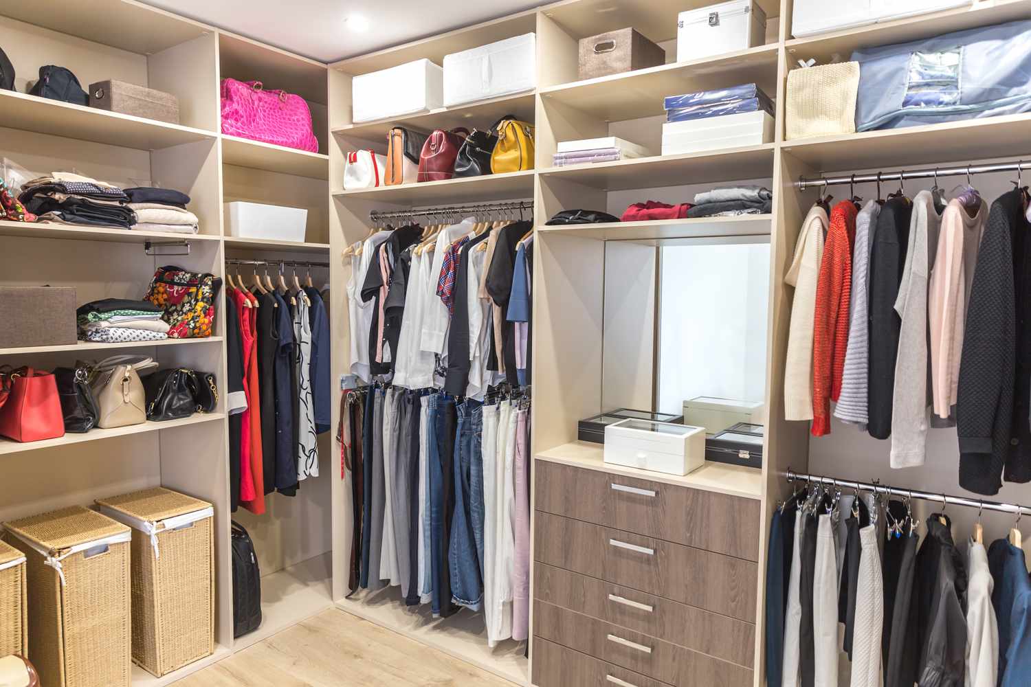 A wellorganized walkin closet featuring hanging clothes shelves with bags and drawers for storage
