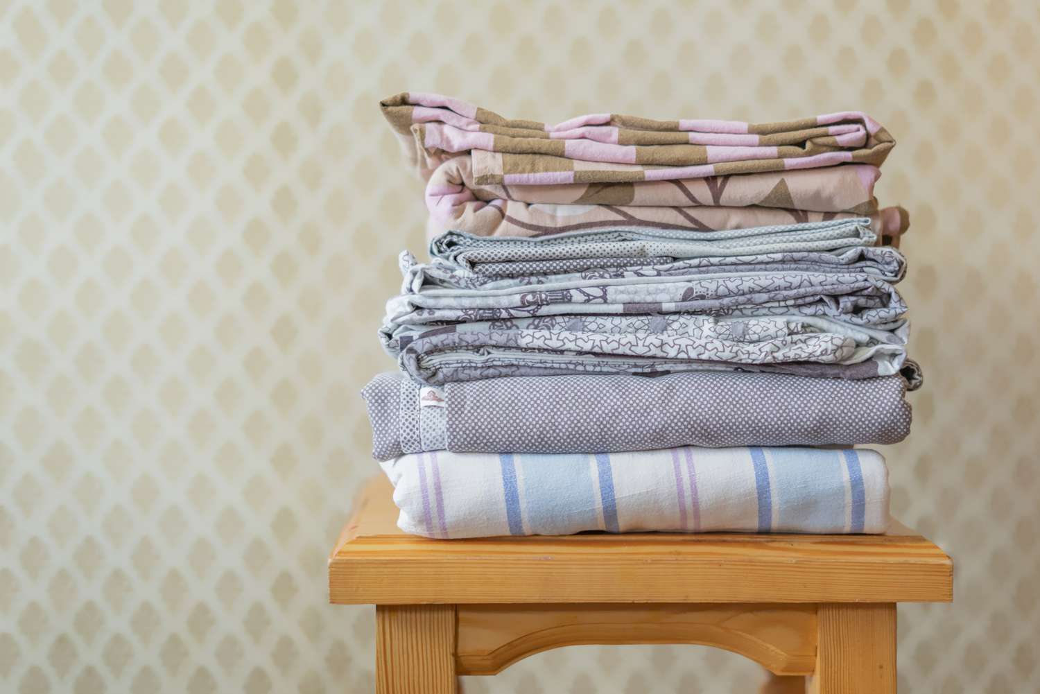stack of textile sheets blankets on a wooden shelf