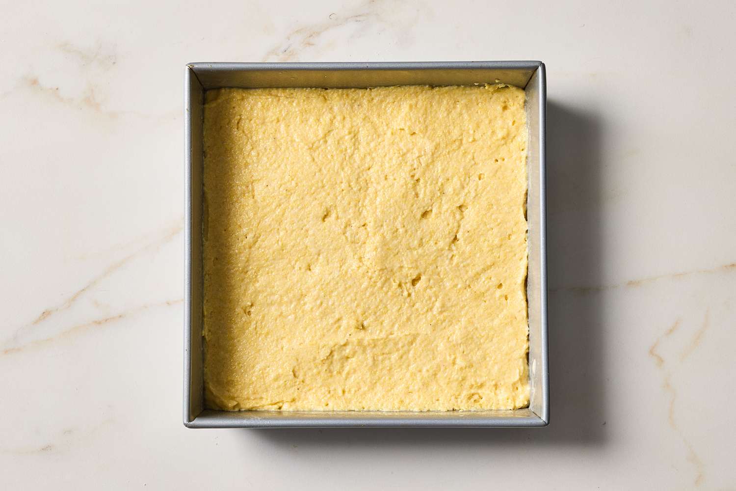 A square baking pan with freshly baked buttermilk cornbread