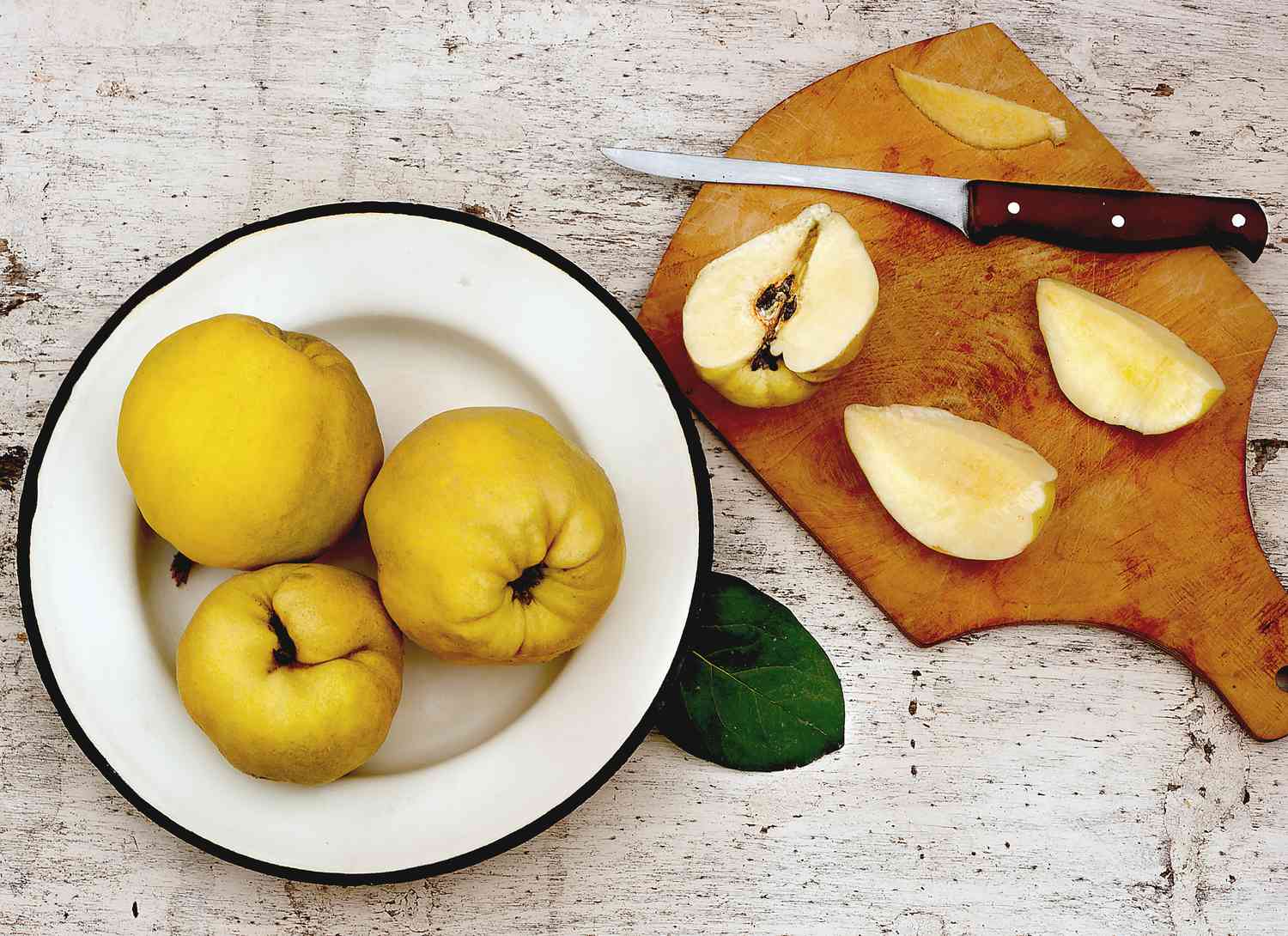 plate of quince and cutting board with cut quince and knife