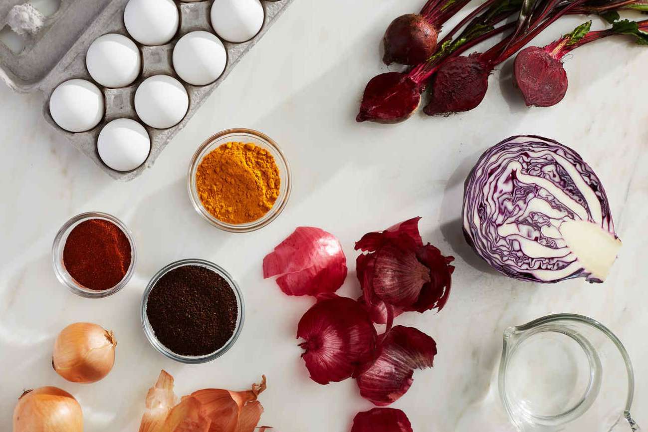 a carton of eggs and natural plant materials for dying