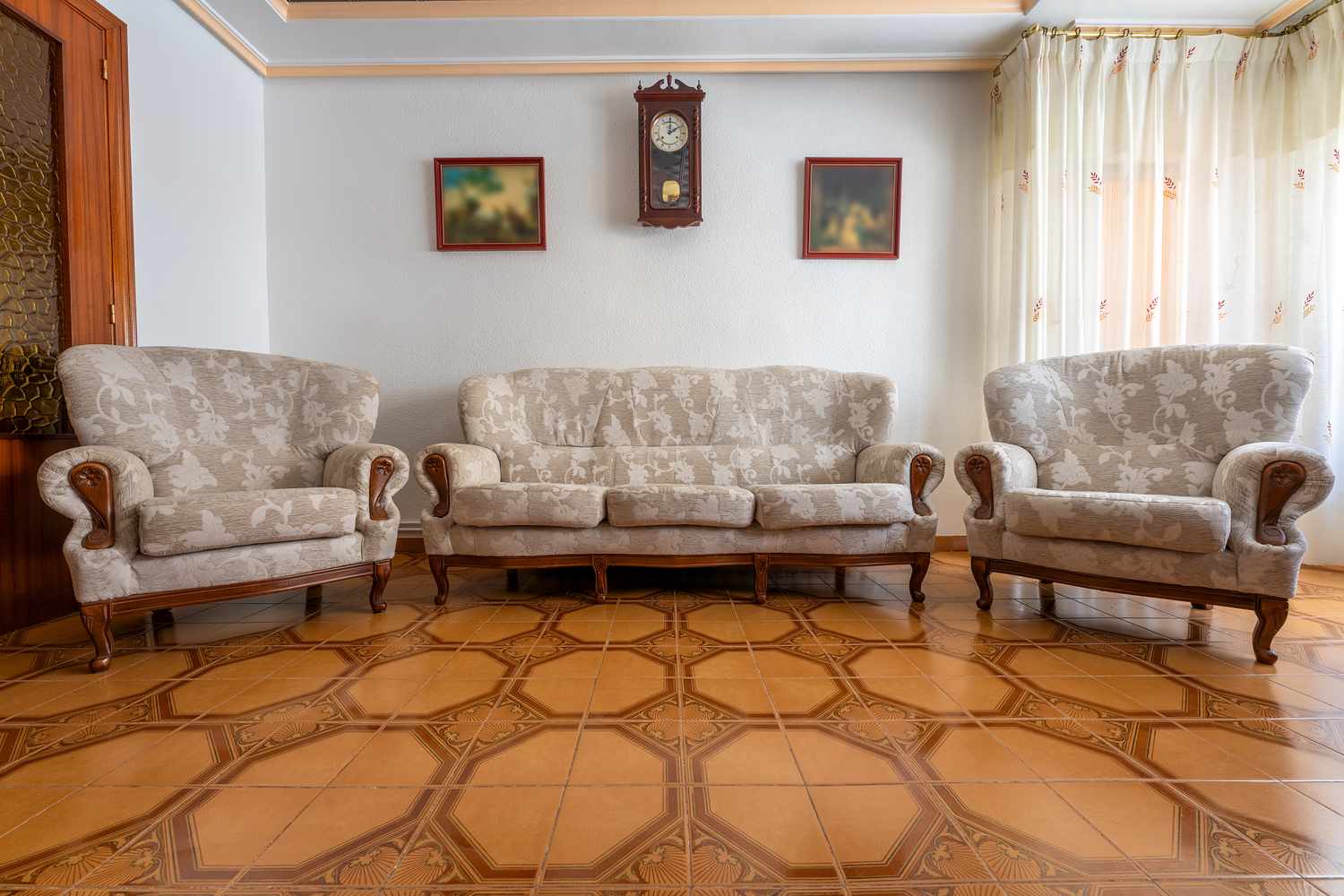 A living room with a sofa set wall clock and framed art