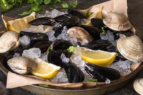a platter of raw clams and mussles with lemon