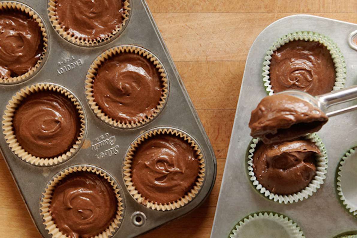 scooping irish stout cupcake batter into baking pan
