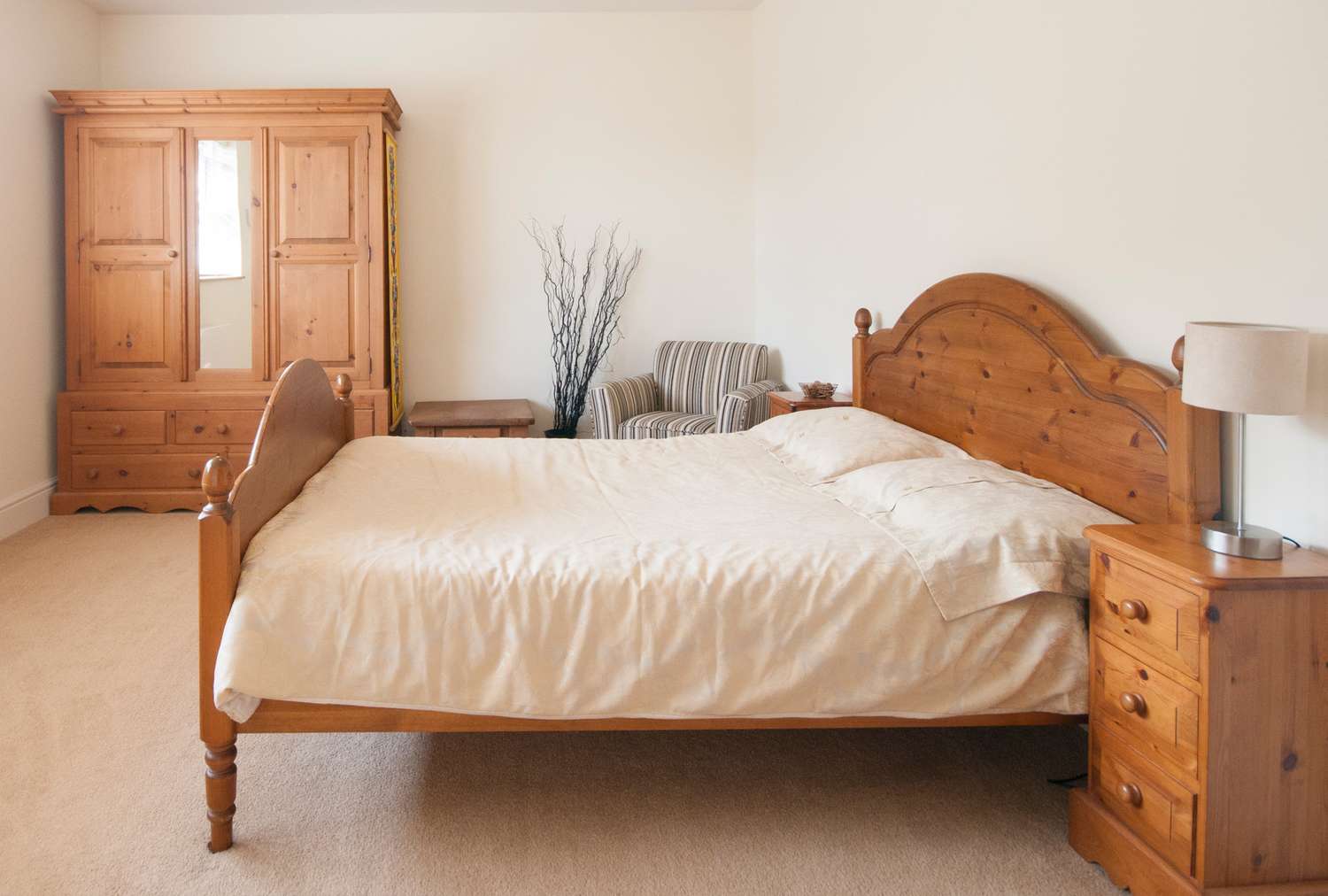 A bedroom set with a bed matching wooden furniture and a chair