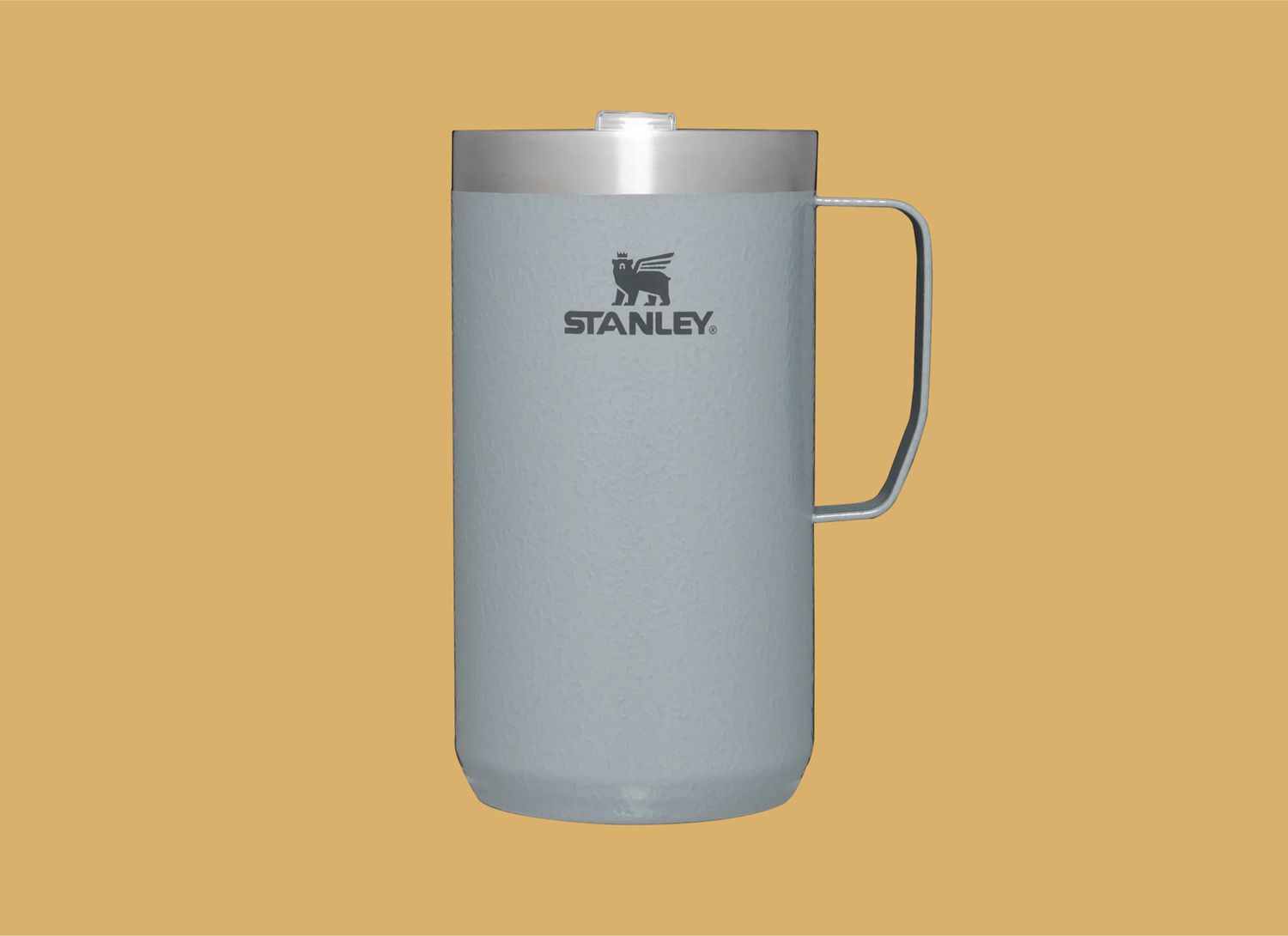 stanley brand silver mug on a yellow background