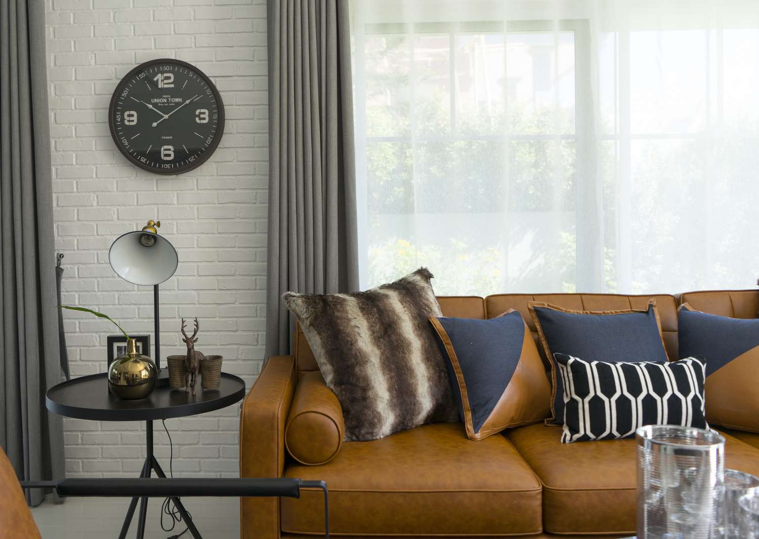 Brown leather couch by window