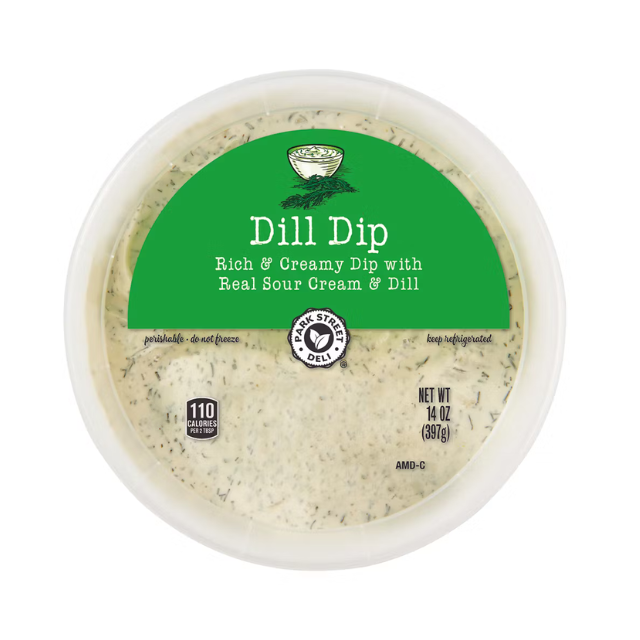 A container of dill dip with sour cream and dill