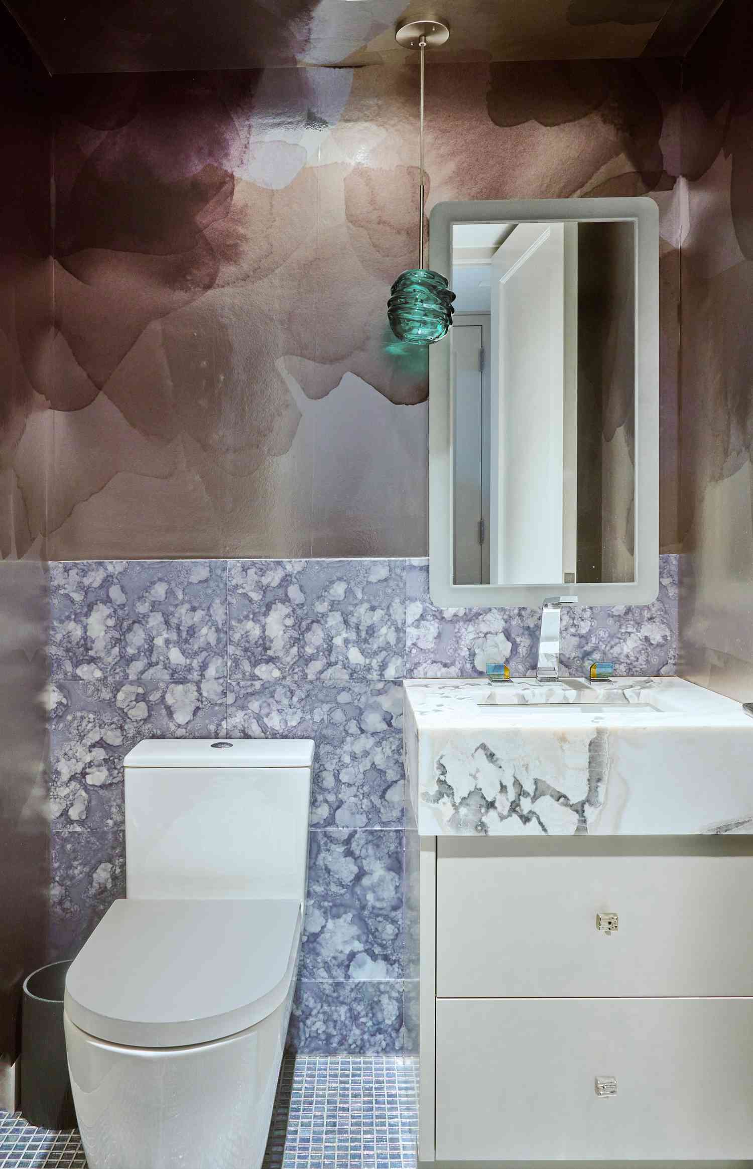 contrasting watercolor wallpaper and marble tile jewel box bathroom