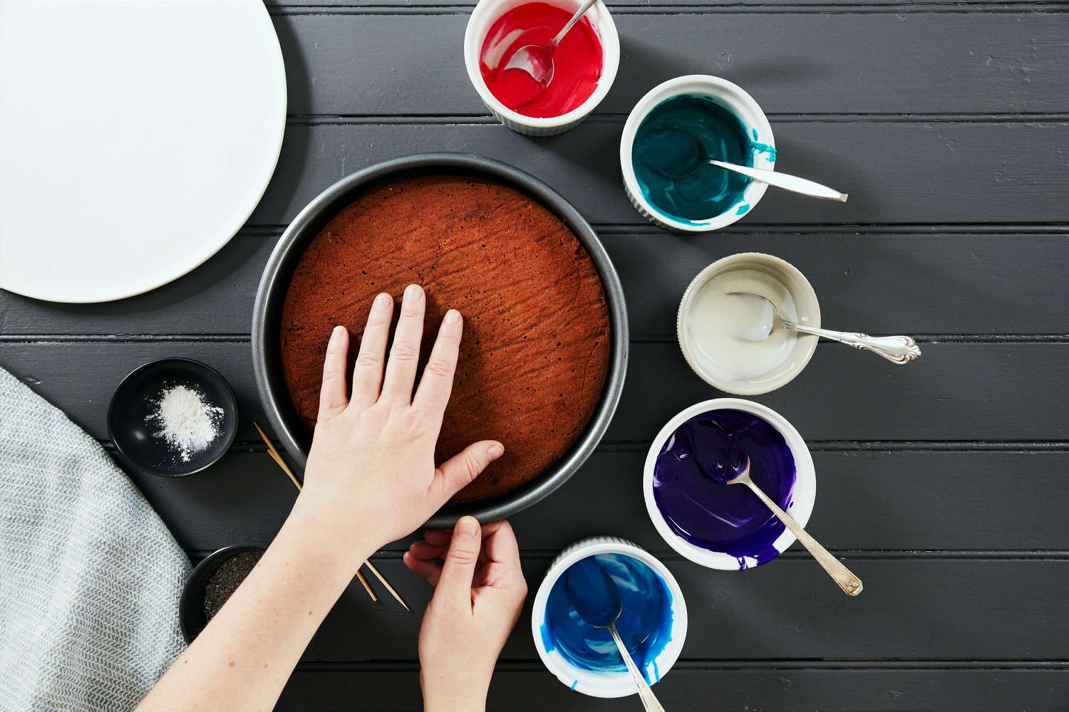 galaxy cake how-to with colored icing bowls hand on cake pan